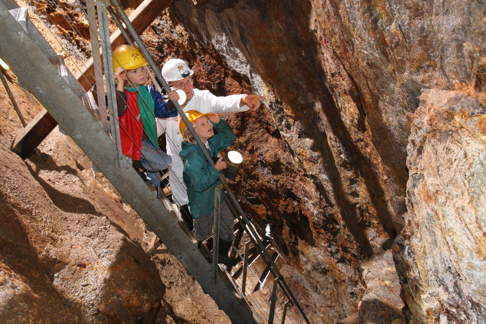 Kinderführung mit Bergwerksführer auf der Treppe im Schacht